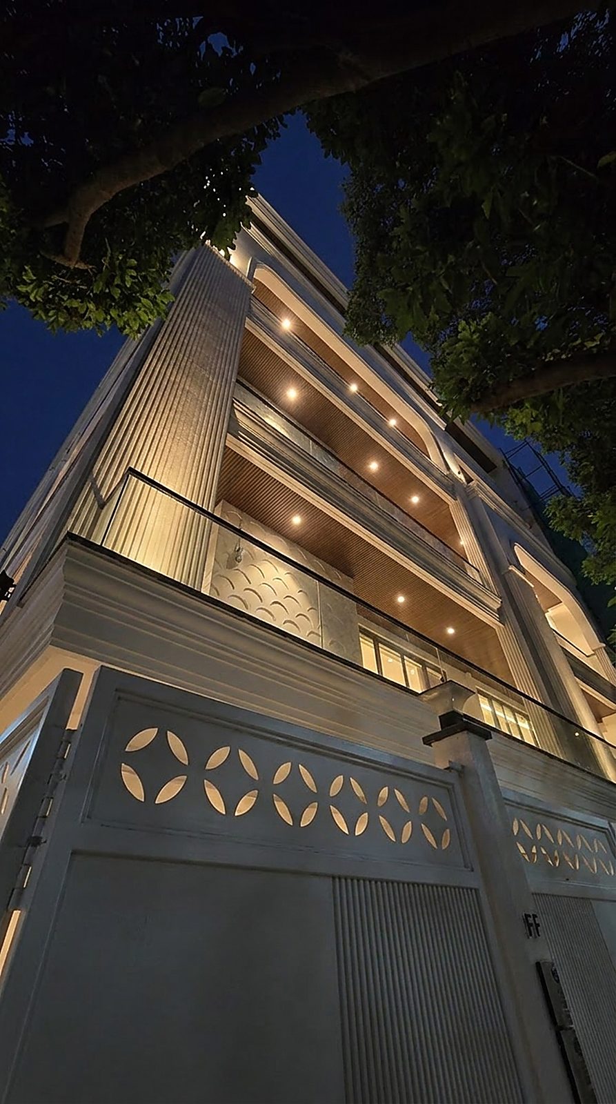 Facade of an Ekum Homes builder floor in Gulmohar Park, South Delhi, with fluted columns, glass balustrades and a jaali-pattern gate