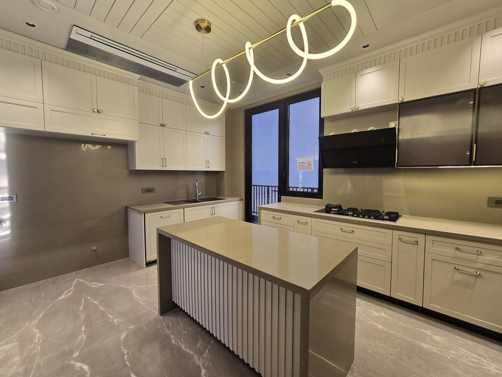 Ekum Homes modular kitchen in South Delhi fitted with Miele appliances, a fluted island base and shaker cabinetry