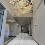 Double-height foyer with a designer chandelier and marble flooring in a penthouse in Greater Kailash 2, South Delhi