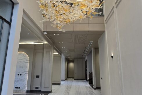 Double-height foyer with a designer chandelier and marble flooring in a penthouse in Greater Kailash 2, South Delhi