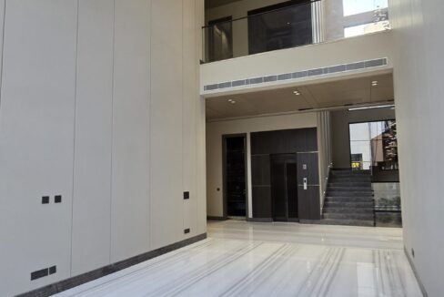 Double-height marble lobby with staircase and private lift in a duplex in Chanakyapuri, Malcha Marg, South Delhi