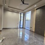 Master bedroom with grey marble floor and padded feature wall at an Indus Homes luxury villa