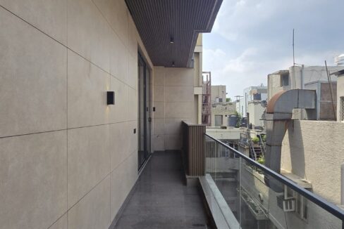 Balcony with a glass railing overlooking greenery in a builder floor in Chanakyapuri, Malcha Marg, South Delhi