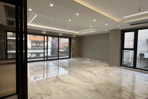 Open living room with floor-to-ceiling sliding windows and European marble flooring in the 4 BHK builder floor in Geetanjali Enclave, South Delhi.