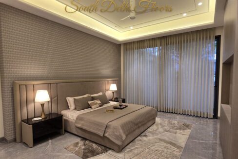 Furnished master bedroom of the 3 BHK in Vasant Vihar, A Block, with an upholstered headboard and marble floor