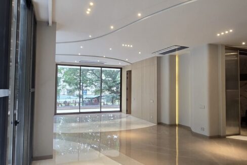 Drawing room with a curved marble inlay and cove-lit ceiling in a home by the developer of this 4 BHK in Panchsheel Park