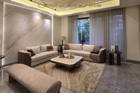 Furnished living room of the apartment in Vasant Vihar, B Block: Italian marble floor, marble feature wall and bespoke sofas
