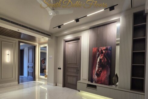 Living room with built-in shelving and artwork in a home by the developer of the biggest penthouse in South Delhi