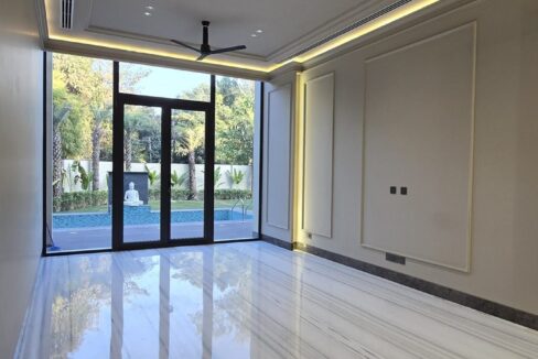 White marble living room opening to a garden in a home by the developer of this builder floor in Anand Lok