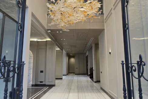 Grand entrance foyer with a wrought-iron door and glass-leaf chandelier in a home by the developer of this builder floor in GK-2 M Block