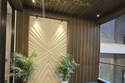 Entrance lobby with a sculpted feature wall and planters in a home by the developer of this builder floor in Maharani Bagh