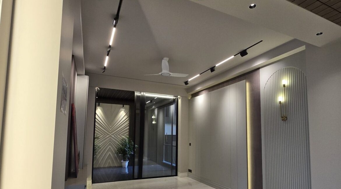 Corner home in Anand Niketan – living room with fluted niche and sconce