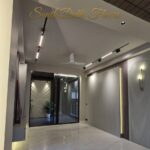 Living room with an arched fluted niche and brass sconce in a home by the developer of this corner home in Anand Niketan