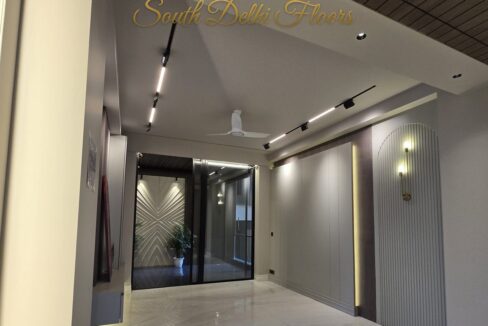 Living room with an arched fluted niche and brass sconce in a home by the developer of this corner home in Anand Niketan