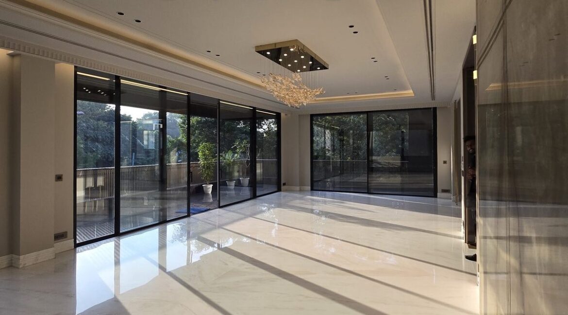 Corner home in Anand Niketan – sunlit living room with trees on two sides