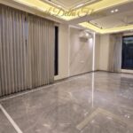 Drawing room of the duplex in Vasant Vihar, A Block, with Italian marble floors, a marble wall and cove lighting