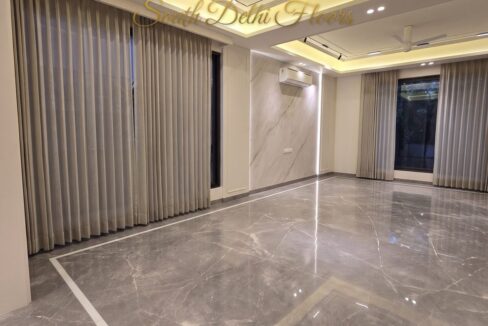 Drawing room of the duplex in Vasant Vihar, A Block, with Italian marble floors, a marble wall and cove lighting