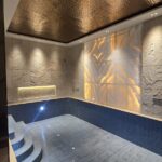 Indoor pool with a backlit onyx wall and curved steps in a home by the developer of the duplex with pool in Pamposh Enclave, GK-1
