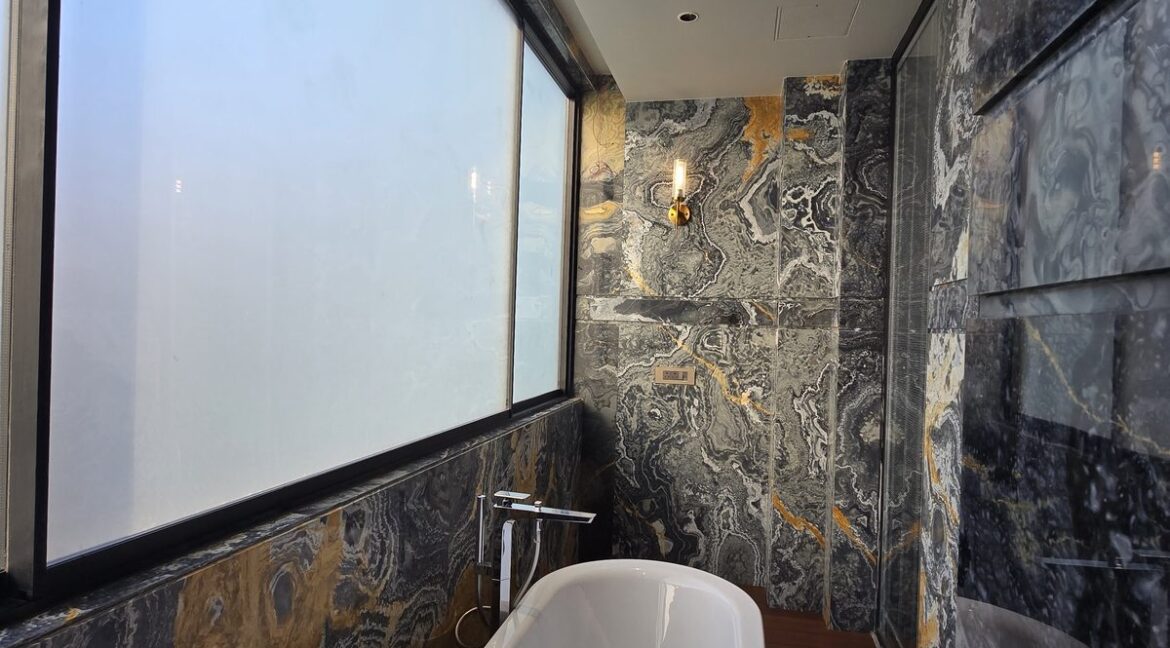 Ekum Homes Bathtub Beneath Frosted Window