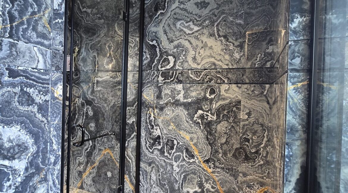 Ekum Homes Glass Shower With Swirled Marble Cladding