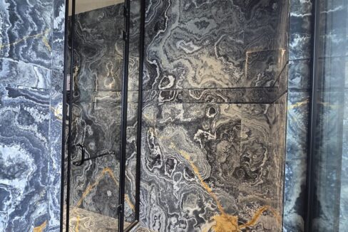 Ekum Homes Glass Shower With Swirled Marble Cladding