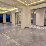 Open-plan living and dining of the house in Vasant Vihar, E Block: Italian marble floors, chandelier and cove lighting
