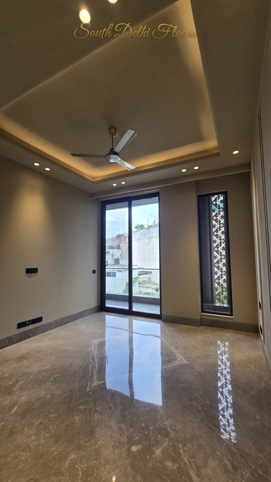 Bedroom with cove-lit ceiling, glazed balcony door and decorative jaali screen window at an Indus Homes builder floor in Greater Kailash-1, South Delhi