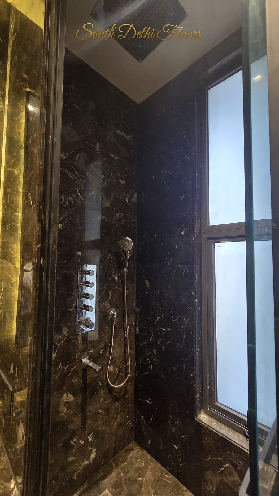 Dark brown European marble shower enclosure with body-jet panel and window at an Indus Homes builder floor in GK-1, South Delhi