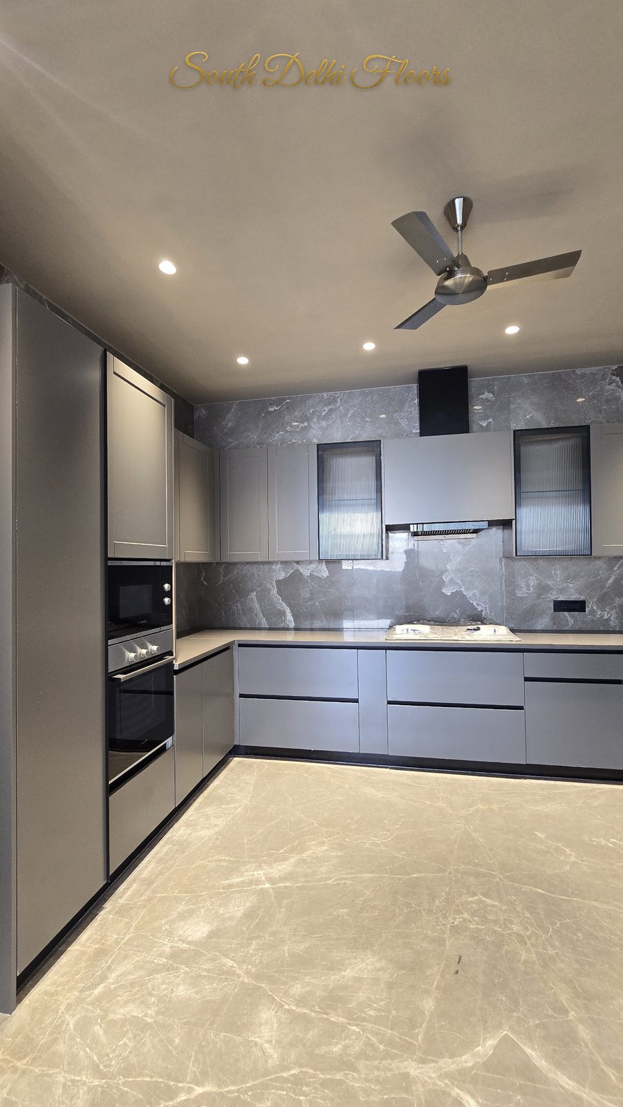 Modular kitchen with built-in oven and microwave column, grey shutters and Italian marble floor at an Indus Homes builder floor in Greater Kailash-1