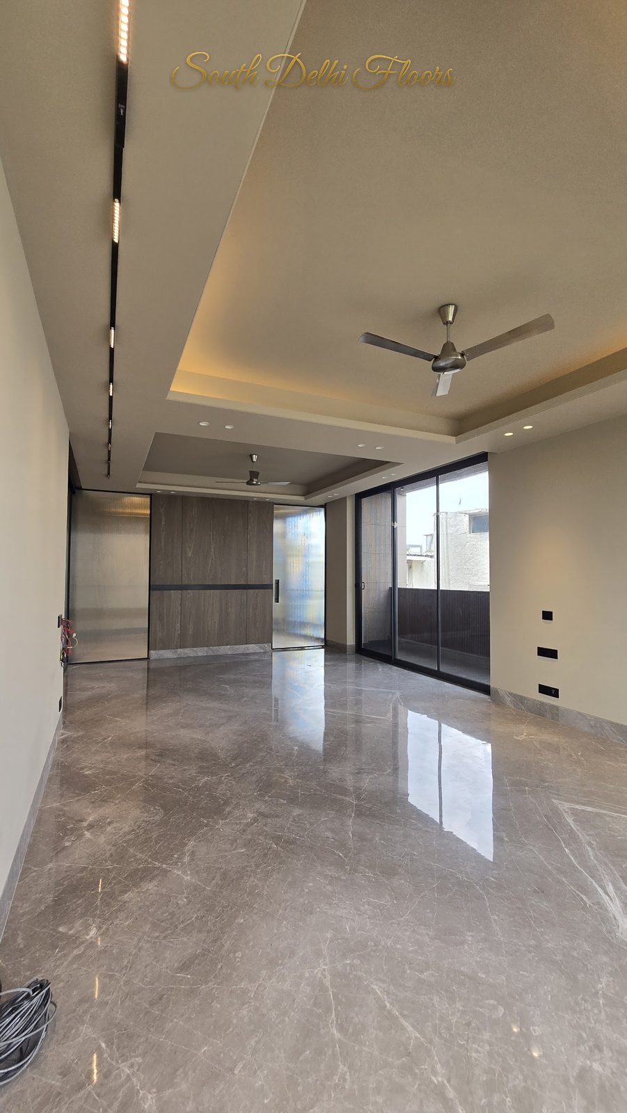 Living and dining room with grey Italian marble floor and cove-lit false ceiling at an Indus Homes builder floor in Greater Kailash-1, South Delhi