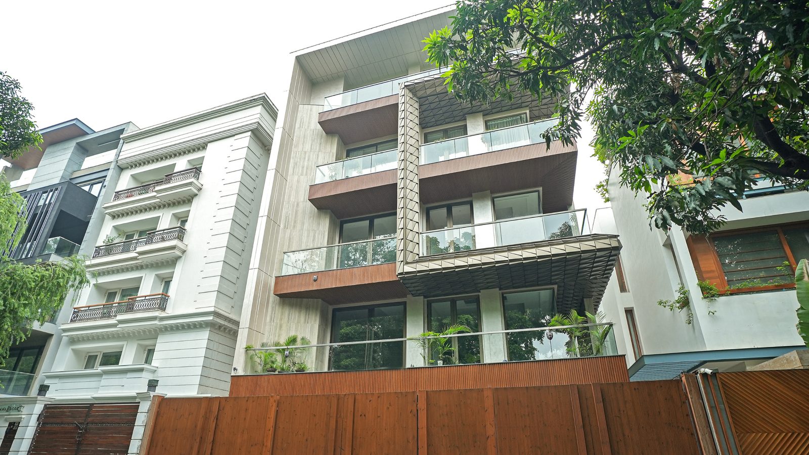 65 Anand Lok, a Katarias (Kataria Buildcon) residence with glass-railed balconies among mature trees