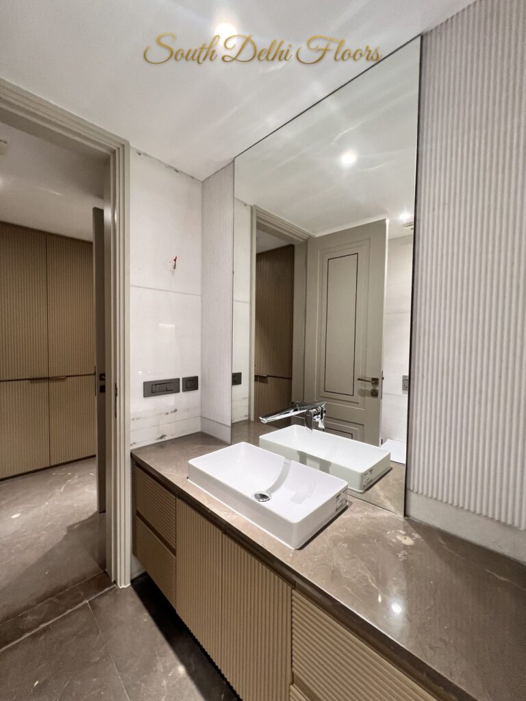 Bathroom vanity with a mirror wall, rectangular vessel basin and fluted wood drawers at a Katarias luxury residence in South Delhi by developer Sandeep Kataria