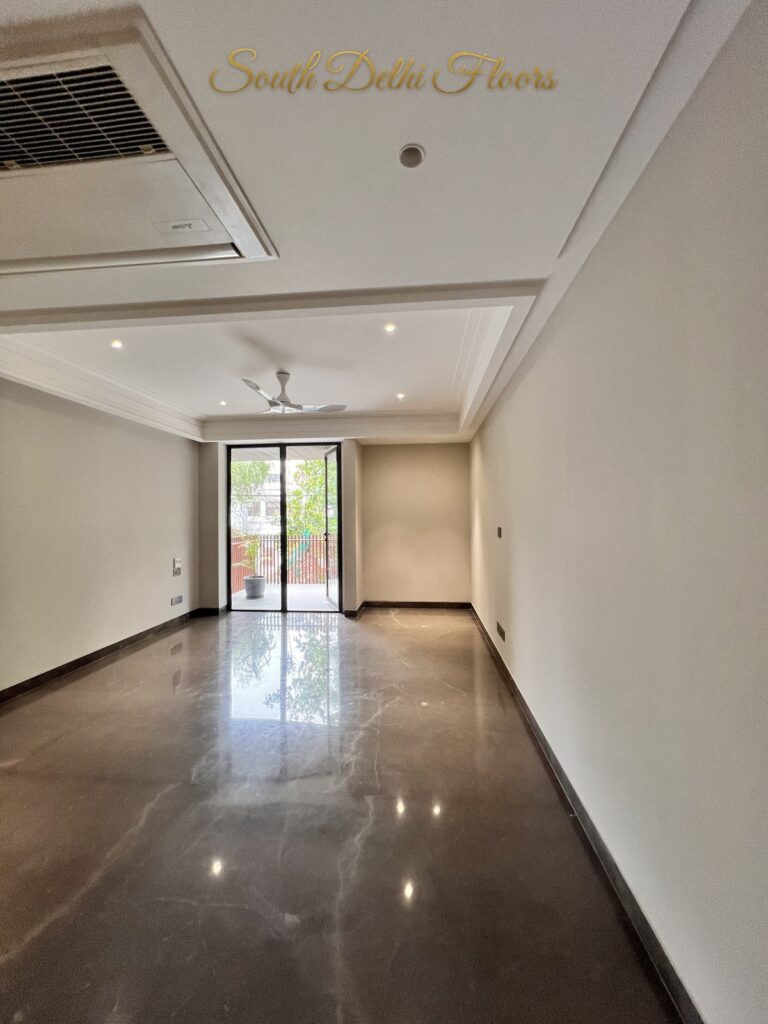 Bedroom with brown marble flooring, a cove ceiling and a glazed door opening to the balcony at a Katarias luxury property in South Delhi by Sandeep Kataria