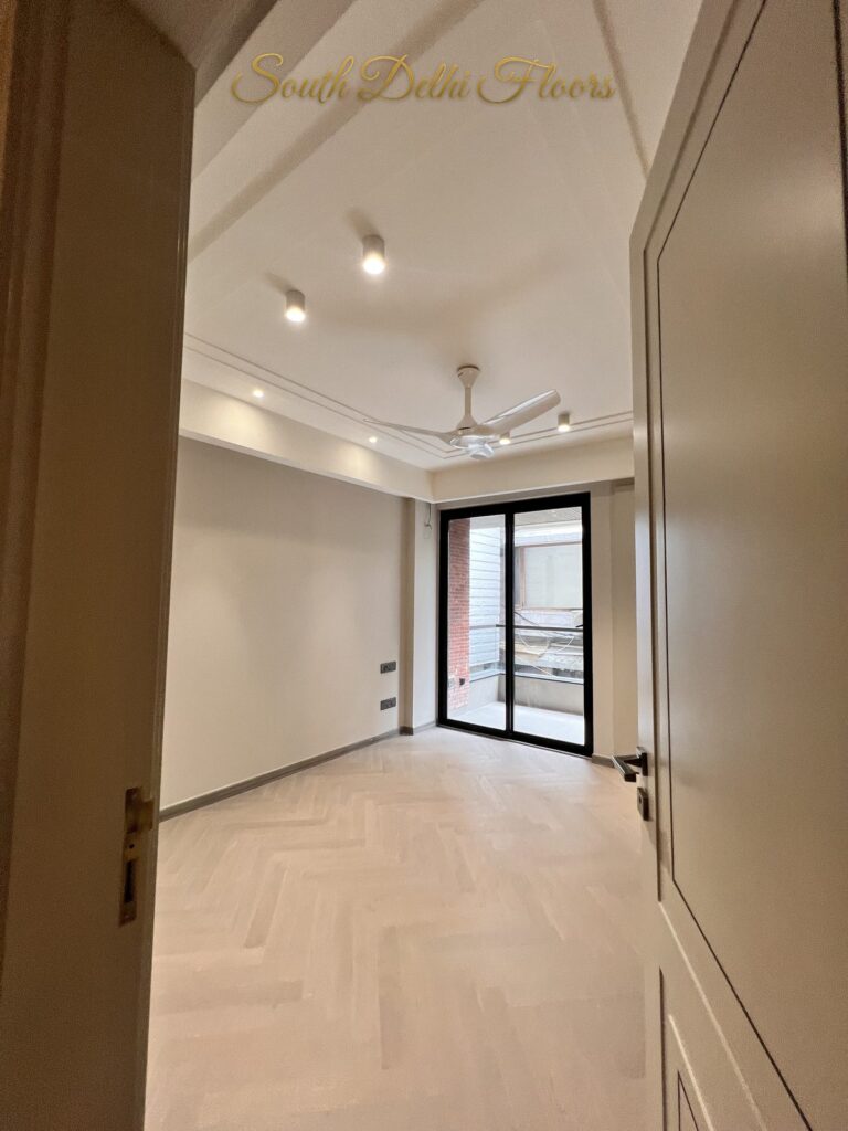 Bedroom with herringbone flooring, a white ceiling fan and glass doors to the balcony at a Katarias luxury builder floor in South Delhi by Sandeep Kataria