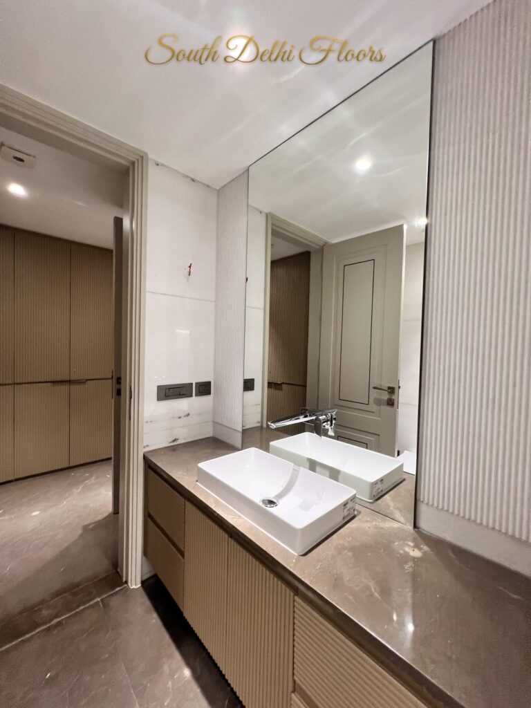 Ensuite bathroom vanity with a vessel basin and stone counter, with the dressing room beyond at a Katarias luxury property in South Delhi by Sandeep Kataria