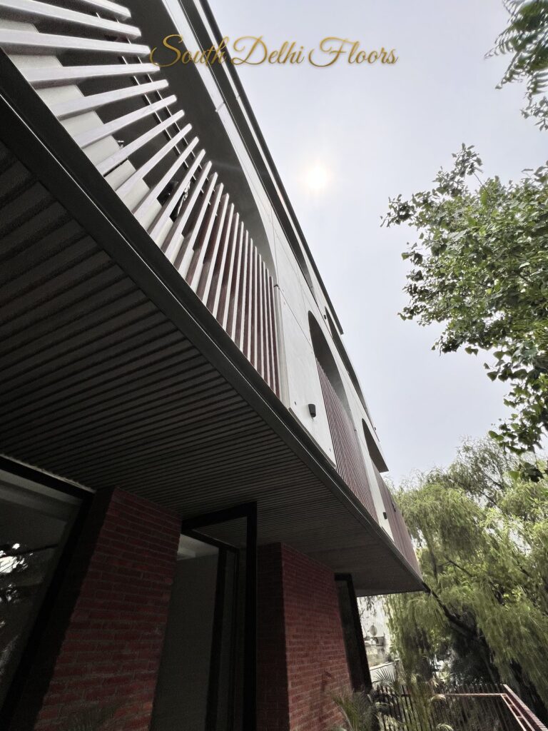 Upward view of the facade showing the ribbed canopy soffit, vertical louvres and exposed brick at a Katarias luxury property in South Delhi by Sandeep Kataria