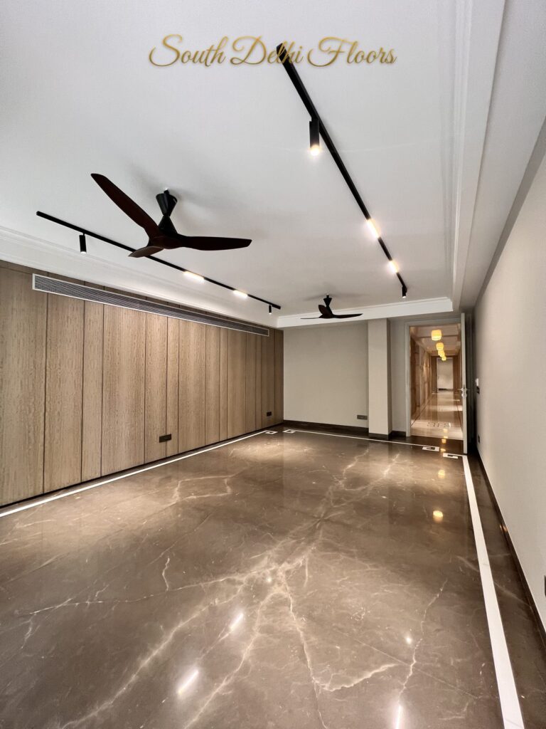 Living room with vertical wood wall panels, linear track lighting and a view to the corridor at a Katarias luxury residence in South Delhi by developer Sandeep Kataria