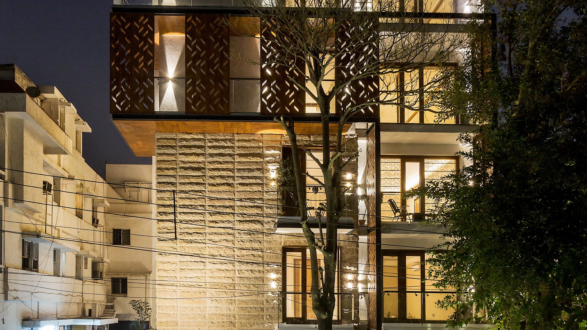 Dusk view of S-236 Panchsheel Park, a Katarias (Kataria Buildcon) residence in South Delhi, with perforated stone screens and lit interiors
