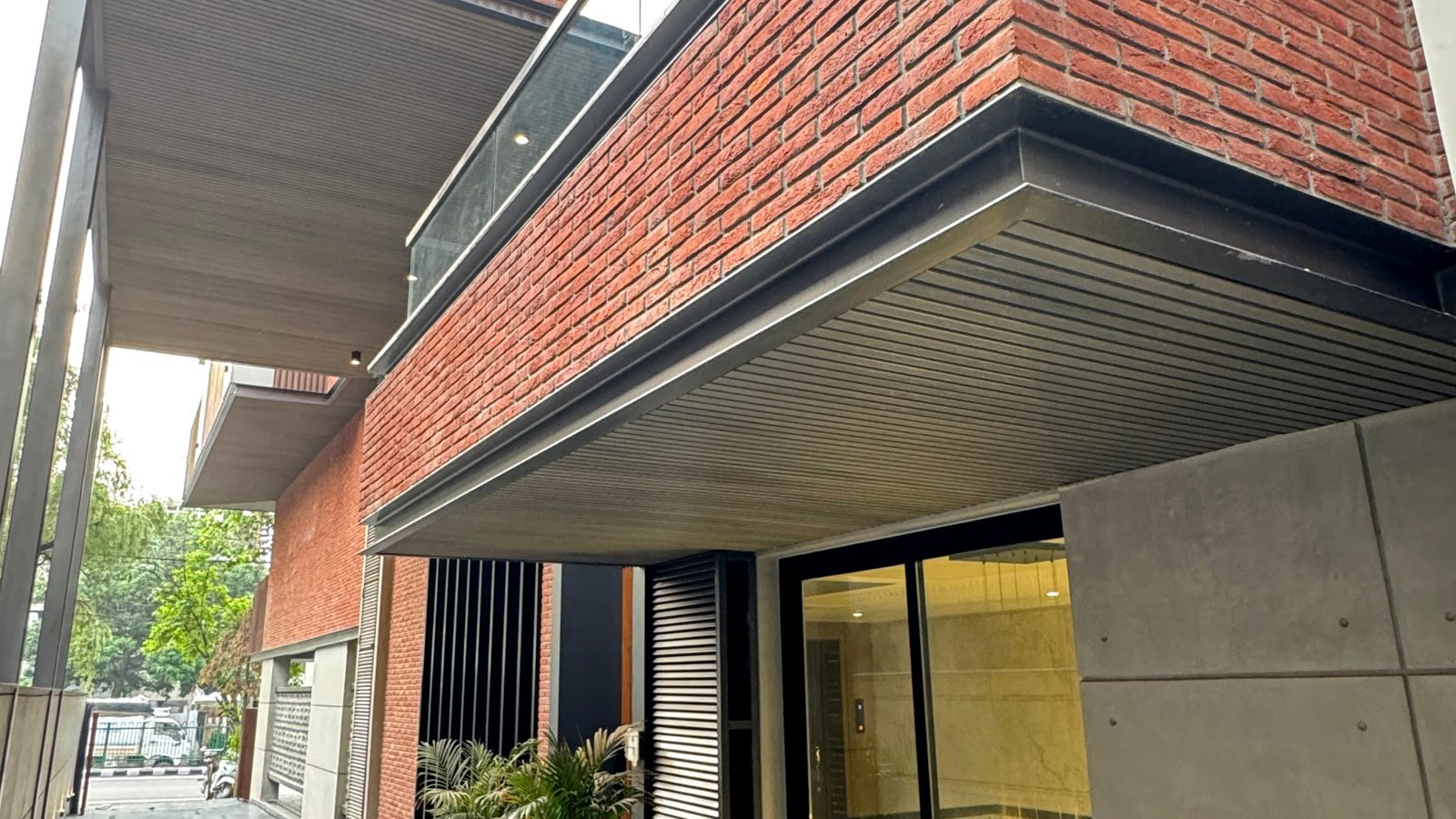 W-98 GK-2, a Katarias (Kataria Buildcon) 550 sq yd residence in Greater Kailash 2 with an exposed-brick cantilever and louvred canopy