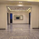 Lounge and dining vista of the park facing flat in Vasant Vihar, E Block, with Italian marble floors and cove lighting