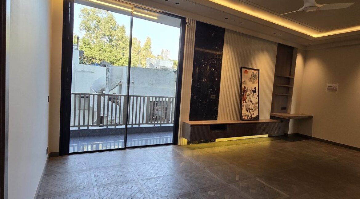 Penthouse in Anand Niketan – living room opening to a balcony and trees