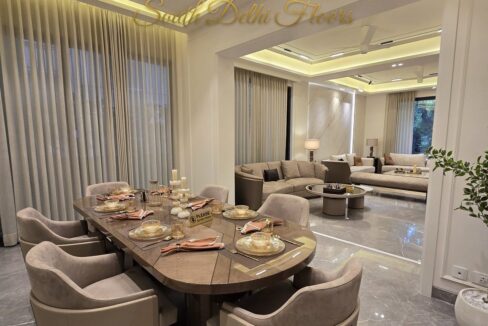Furnished dining and living room of the penthouse in Shanti Niketan with a chandelier and marble floors