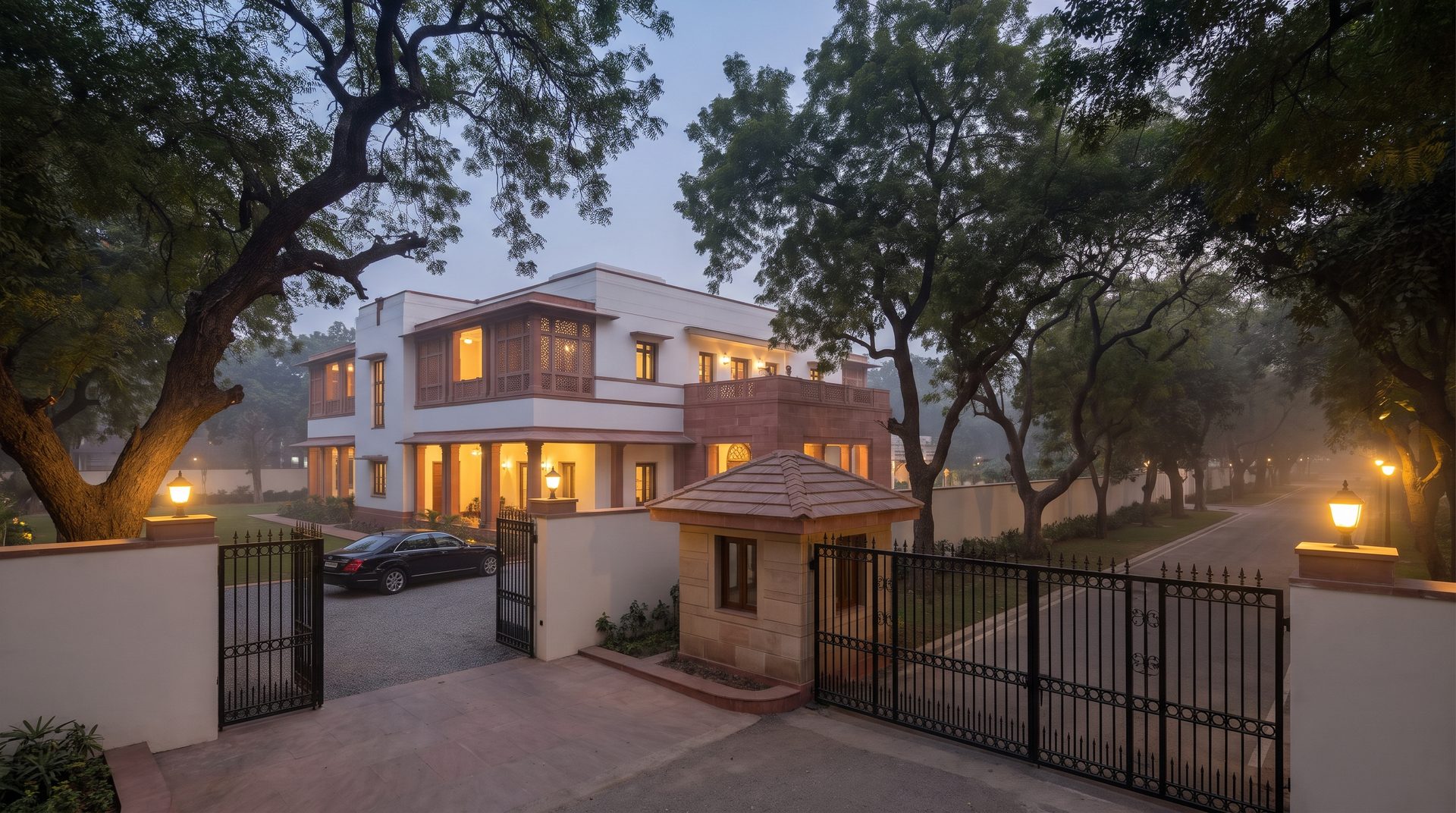 Renting property to an embassy in Delhi &mdash; a gated diplomatic-style residence with a guard post and tree-lined road at dusk in South Delhi