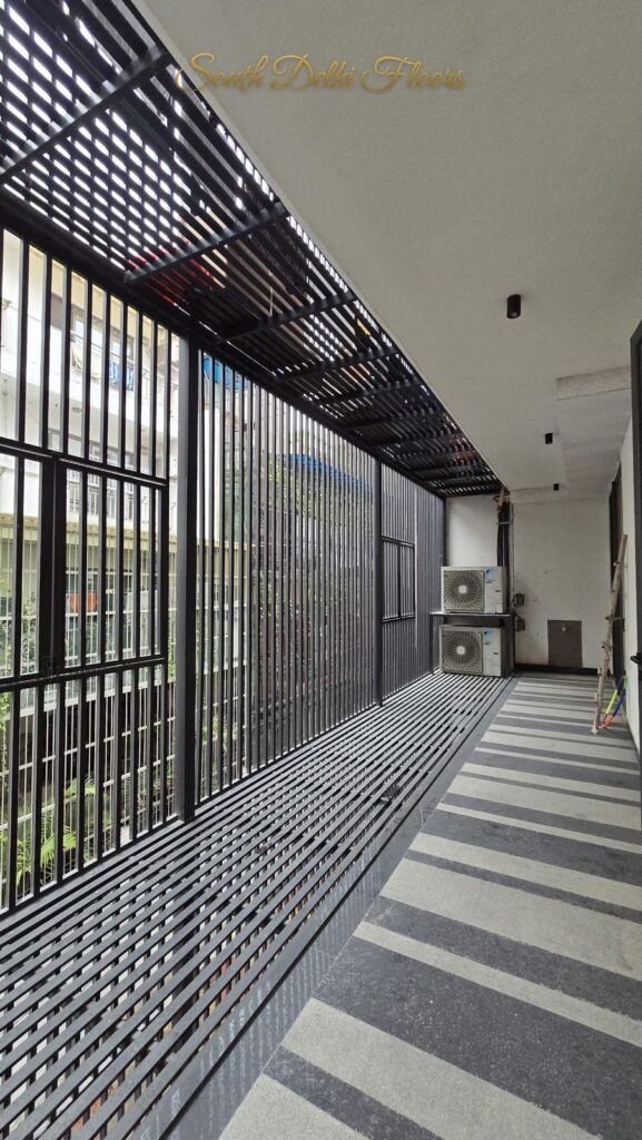 Balcony with a metal louver screen, slatted pergola and granite stripes at an RPB Homes JCR Homes luxury property in South Delhi by Mahavir Bihani and Rajat Bihani