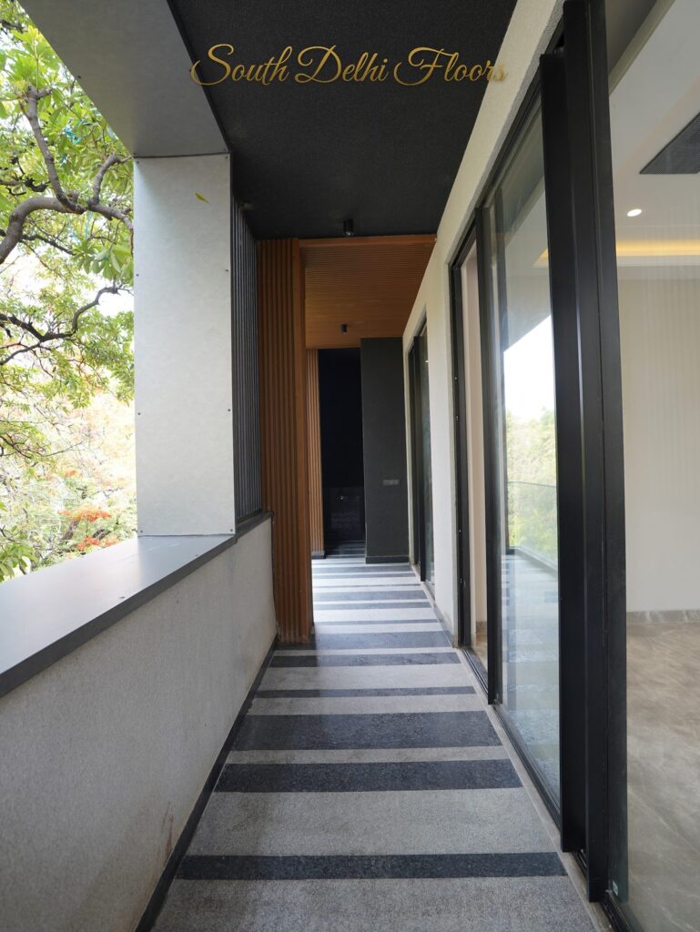 Balcony with wooden slat cladding, striped granite floor and tree view at an RPB Homes JCR Homes luxury residence in South Delhi by developers Mahavir Bihani and Rajat Bihani