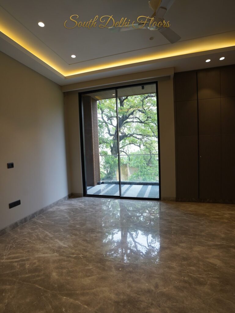 Bedroom with a garden-view glass door, fitted wardrobe and cove lighting at an RPB Homes JCR Homes luxury property in South Delhi by Mahavir Bihani and Rajat Bihani