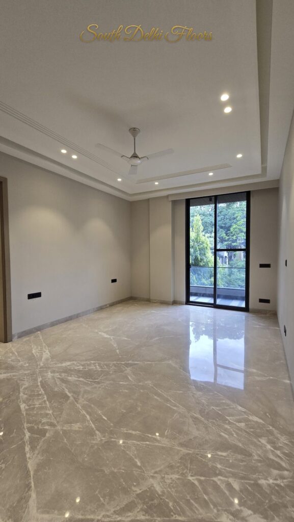 Bedroom with a tray ceiling, balcony door, tree view and cream marble floor at an RPB Homes JCR Homes luxury builder floor in South Delhi by Mahavir Bihani and Rajat Bihani
