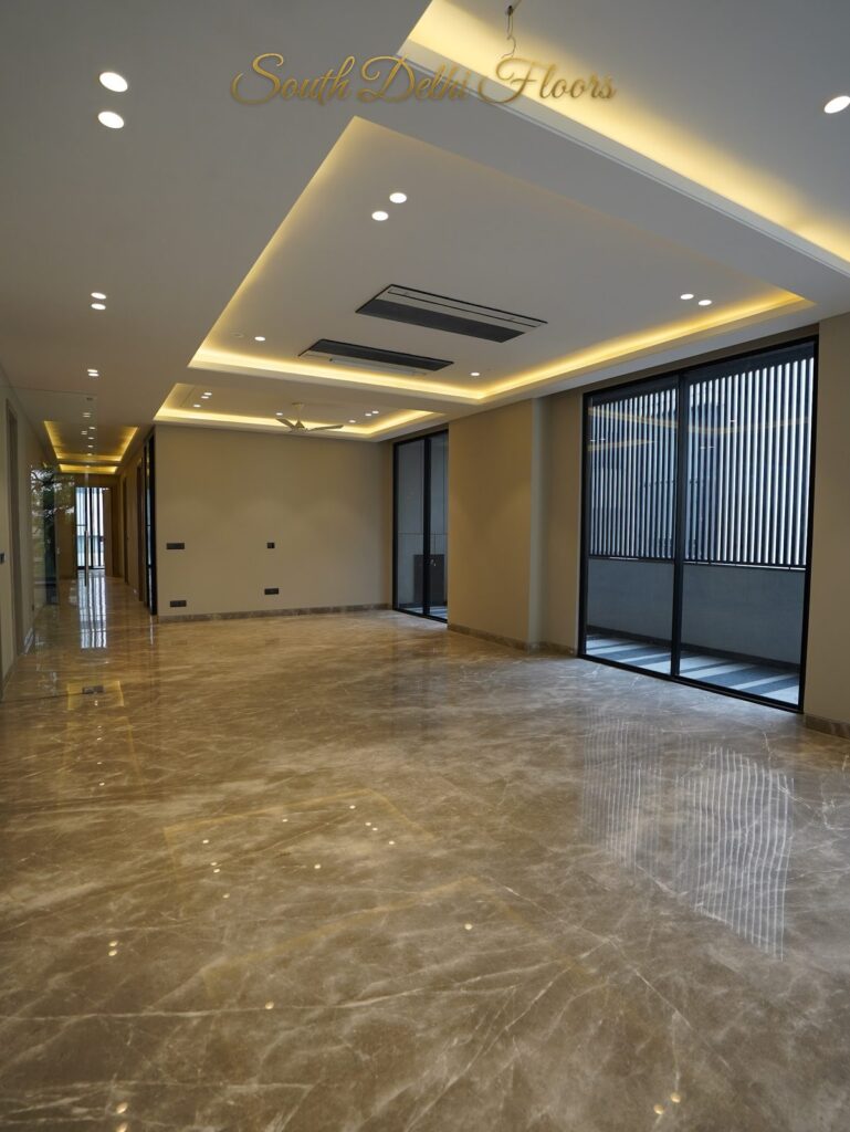 Drawing room with a cove-lit ceiling, long glass wall and polished marble flooring at an RPB Homes JCR Homes luxury builder floor in South Delhi by Mahavir Bihani and Rajat Bihani
