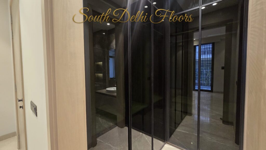 Dressing room with black glass wardrobes at an RPB Homes JCR Homes luxury builder floor in South Delhi by Mahavir Bihani and Rajat Bihani