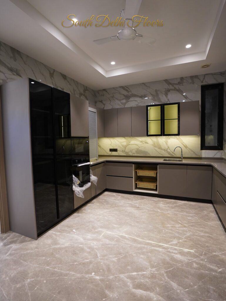 Kitchen with a tall black glass storage unit and marble wall cladding at an RPB Homes JCR Homes luxury residence in South Delhi by developers Mahavir Bihani and Rajat Bihani